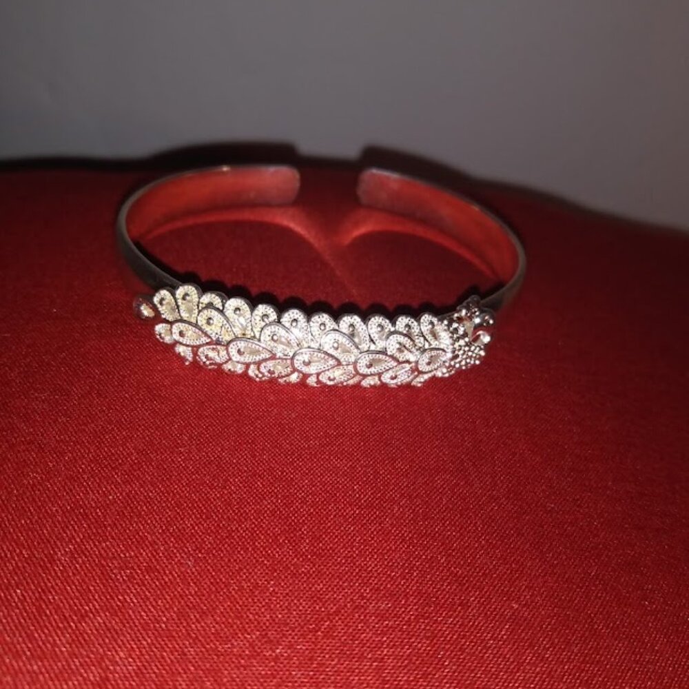 Pretty silver tone peacock design open bangle bracelet.